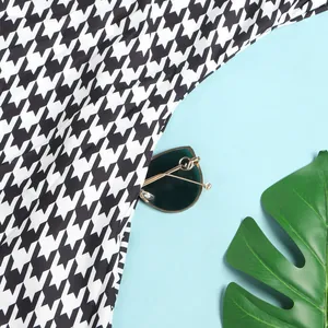 High-quality close-up detail of classic black and white houndstooth pattern fabric for dress