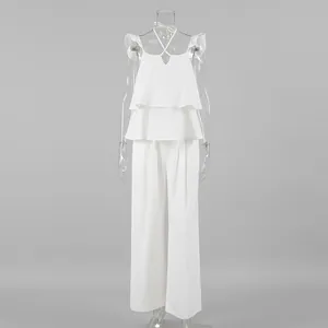 Ensemble deux pièces élégant en coton et lin blanc avec haut à volants et pantalon large.