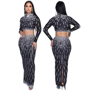 Detail van zwarte tweedeelige formele set met top met lange mouwen en maxi-rok met zijsplit