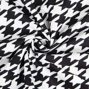 Detailed macro shot of premium black and white houndstooth patterned dress fabric