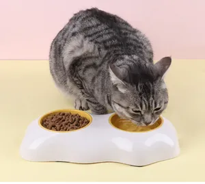 Detail van een cyperse kat die drinkt uit een eigeel dubbel voerbakstation.