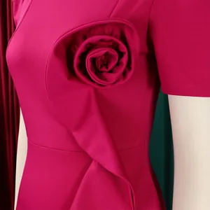 Close-up of elegant magenta dress featuring a 3D ruffled rose detail on the chest.