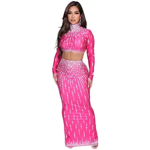 Model in een roze tweedelige partyset met decoratieve patronen van glimmende strassteentjes