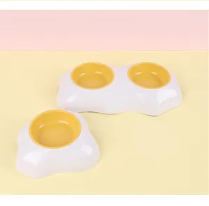 Detailoverzicht van een eivormige geel-witte dubbele voerbak voor katten en honden