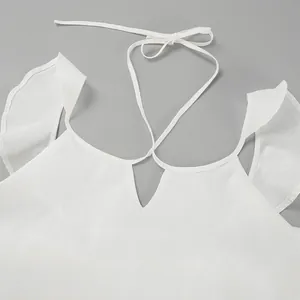 Détail d'un haut en lin blanc avec manches volantées, encolure en V et liens de serrage réglables