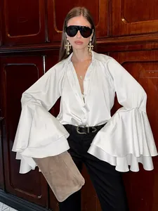 Elegante blusa de satén blanco estilo francés con amplias mangas campana volantes.