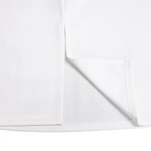 Close-up detail of a white dress hem featuring an elegant split design and fine stitching.
