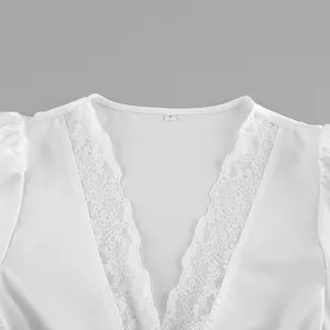 Detail view of exquisite white lace trim on the V-neckline of a satin short-sleeved top