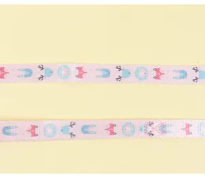 Macro detail of pink cat harness strap featuring cute cartoon fox and rabbit patterns
