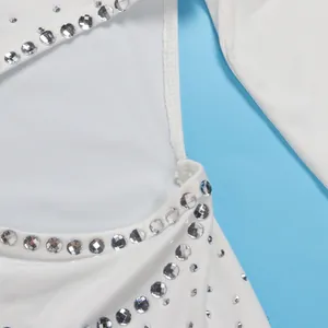 Dettaglio ravvicinato di strass argentati luccicanti su una tuta bianca elasticizzata