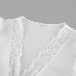 Close-up of white satin V-neck top with delicate lace patchwork trim