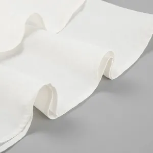 Gros plan sur le tissu en lin blanc de haute qualité avec bordure à volants.