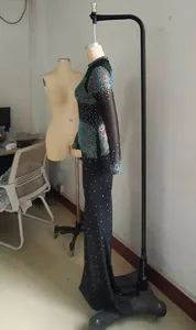 Detalle de un vestido largo negro transparente ajustado con pedrería brillante.