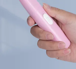 Detailed view of pink handheld cordless pet trimmer with white power switch button