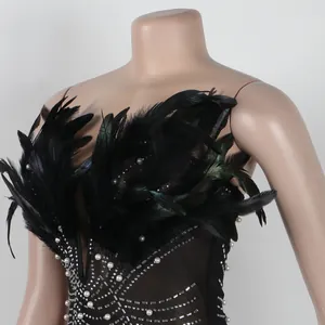 Detailansicht eines schwarzen Bodycon-Partykleides mit Federn und Perlen-Strasssteinen