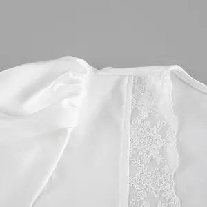 Close-up of the elegant floral lace patchwork on a premium white satin short sleeve top