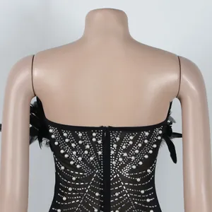 Detailansicht eines schwarzen Kleides mit Perlen, Strass und Federn am Rückenbereich