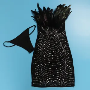 Detailansicht eines sexy schwarzen Bodycon-Kleides mit Federbesatz, Perlen und Strass