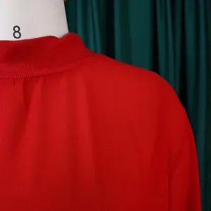 Close-up detail of a red chiffon dress featuring a high ribbed neckline and soft fabric.