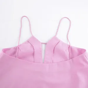 Detail shot of pink linen camisole top featuring thin straps and V-neckline design