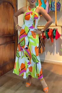 Detailed view of a vibrant orange and green floral print halter maxi dress on a model