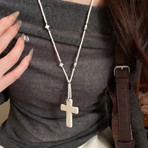 Bohemian white beaded stone cross pendant necklace for women worn on grey sweater