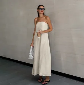 Elegantes trägerloses Maxikleid aus Leinen in Khaki, kombiniert mit Sonnenbrille.