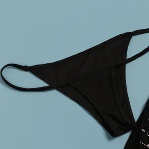 Detailansicht eines sexy schwarzen minimalistischen Thongs für ein enges Minikleid