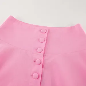 Detailansicht der eleganten runden Knöpfe an einem rosa Rock im französischen Stil.