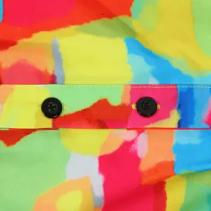 Detailed close-up of vibrant colorful abstract print fabric and black buttons on a dress