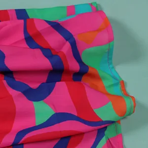 Close-up detail showing the vibrant colorful abstract wavy print on soft dress fabric texture