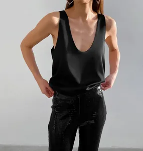 Nahaufnahme des eleganten schwarzen Satin-Tops, das Seidenglanz und tiefen V-Ausschnitt betont