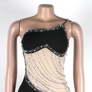 Dettaglio di abito sexy in rete con decorazioni di perle e strass e taglio monospalla elegante