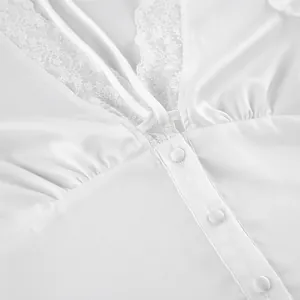 Detailed macro view of white satin top featuring delicate lace V-neck and covered buttons