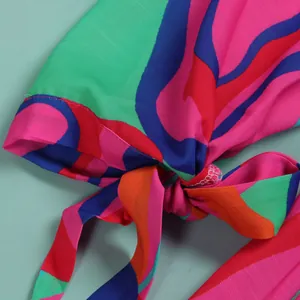 Close-up detail of a colorful abstract print dress featuring a stylish front knot.