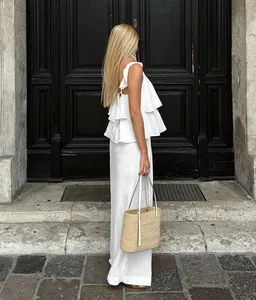 Vue lifestyle d'un ensemble deux pièces en lin blanc avec haut à volants et pantalon large