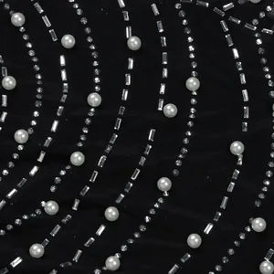 Nahaufnahme von schwarzem Kleiderstoff verziert mit Perlen und Heißfixier-Strass