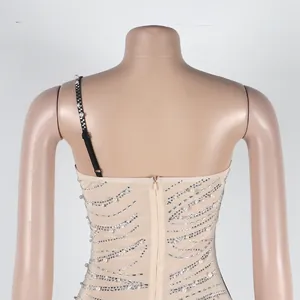 Dettaglio posteriore di un vestito sexy in mesh nude con perle e strass di lusso.