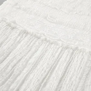 Detailed view of elegant white lace fabric with intricate floral embroidery patterns.