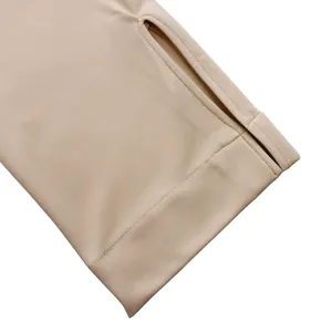 Détail de la manche d'une robe beige avec une conception de poignet à passe-pouce