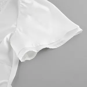 Close-up of white satin sleeve with delicate lace trim on feminine top
