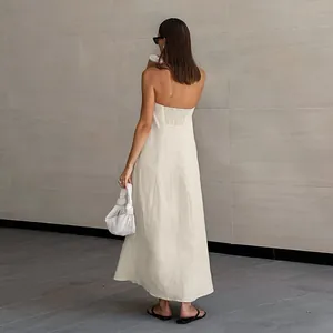 Elegante Rückansicht eines trägerlosen Maxi-Leinenkleides in Beige mit gesmoktem Detail.