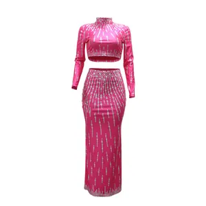Levendige roze tweedelige feestjurkset met crop top met lange mouwen en bijpassende lange rok