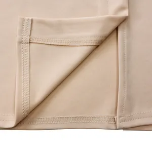 Vue détaillée de la couture fine et de l'ourlet sur une robe élégante couleur abricot
