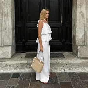 Vue latérale mannequin portant un ensemble en lin blanc avec top à volants et pantalon large