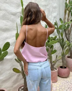 Back view of a sexy pink linen camisole paired with light blue jeans in a cactus garden
