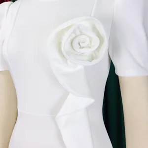 Macro view of elegant white dress featuring a large 3D fabric rose and delicate ruffle detail