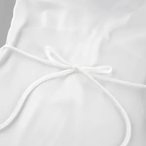Detailed macro view of an elegant white satin bow tie on a luxury summer dress