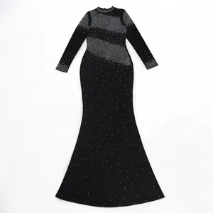 Vista detallada de un elegante vestido de sirena negro con pedrería y mangas largas