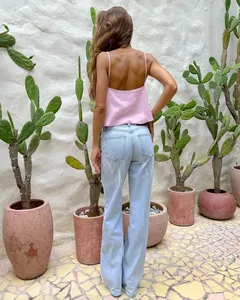 Stylish back view of a sexy pink linen camisole top paired with light blue denim jeans.